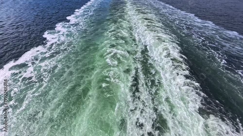 August 13, 2024 - Tracy Arm, USA - Boat wake creates a pattern in the water along Tracy Arm waterway. The boat cuts through the water leaving the foamy trail behind it.
