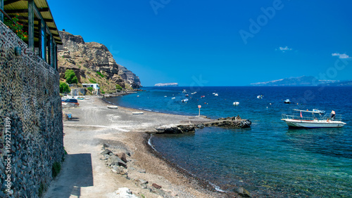 Foto Stunning coastal landscape of Santorini with rugged mountains and deep blue Aege