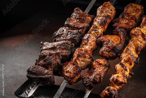 Tableau sur toile Grilled meat skewers assortment with charred texture