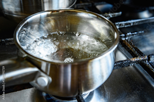 Boiling water in a saucepan Preparing oatmeal porridge in a saucepan.