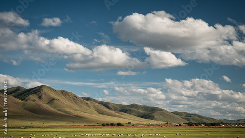 Mongolian plains under clear midday sky, lush green fields contrasting against crisp blue atmosphere, goats as tiny specks near distant gers, towering white clouds, sharp light shadows, vertical cinem