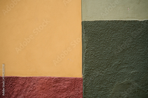 A colorful wall section in San Miguel de Allende, Guanajuato, Mexico, showcasing textured surfaces and vibrant painted areas with distinct regional architectural character.