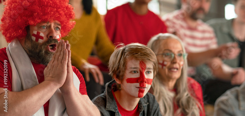 Obraz na plátně Excited football fans supproting English national team in live soccer match at stadium
