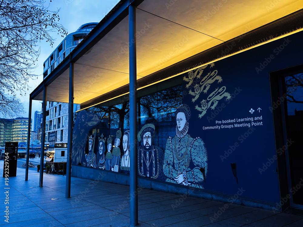 Obraz premium Evening entrance mural at a London, UK learning and community meeting point with historic royal portraits and modern architecture under warm canopy lighting