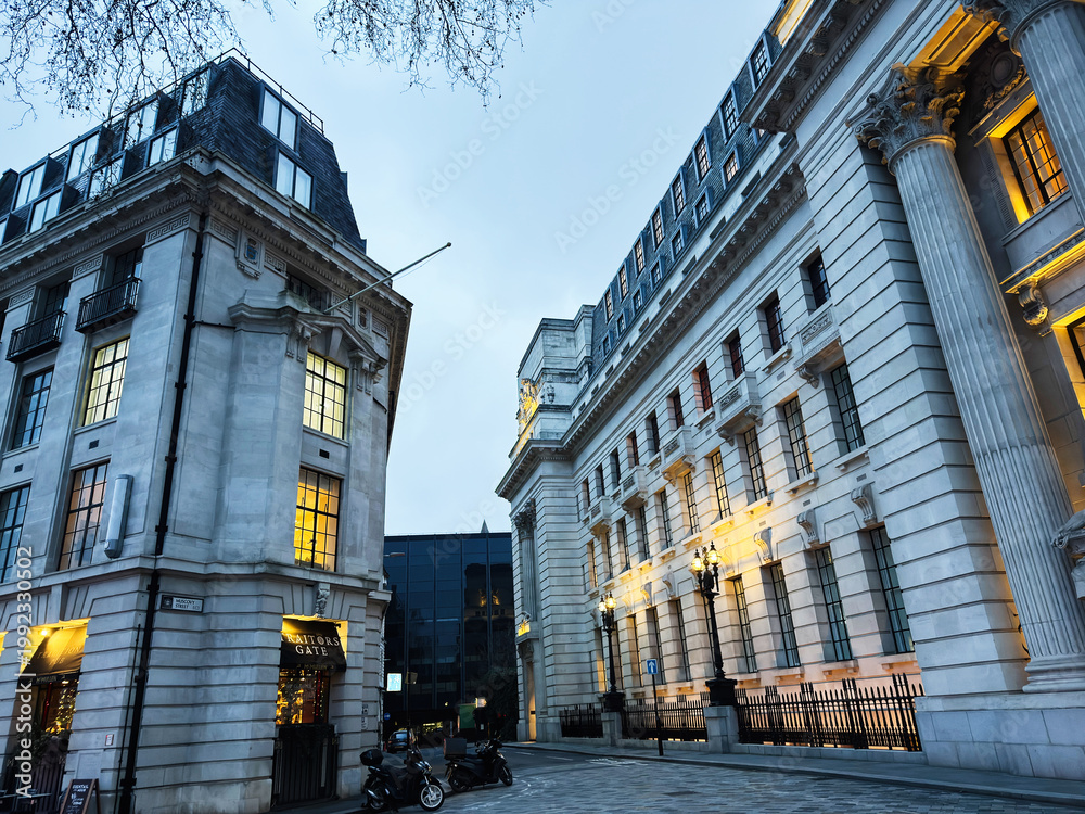 Obraz premium Evening city Muscovy street in London UK with historic neoclassical architecture, Traitors Gate illuminated facades and columns at blue hour