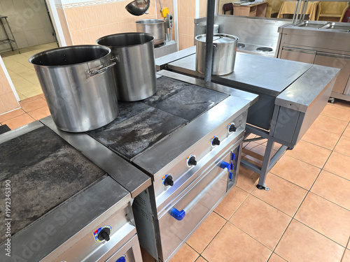 Industrial kitchen. A modern, sleek kitchen with stainless steel cookware, including countertops, pots, and stovetops.