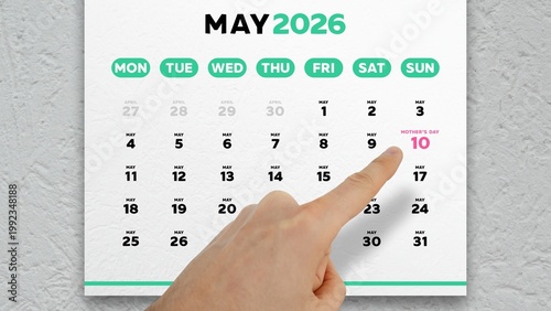 Close-up of a male hand pointing finger at the date of Mother's Day 2026 on a wall calendar