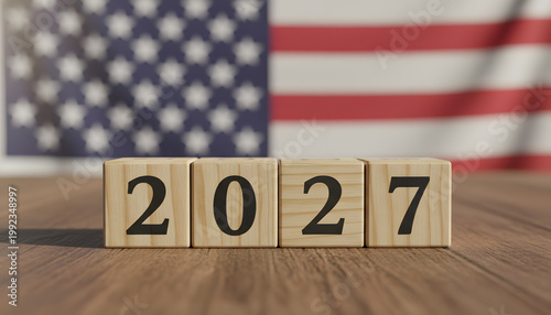 A wooden block display of the year 2027 in front of the American flag