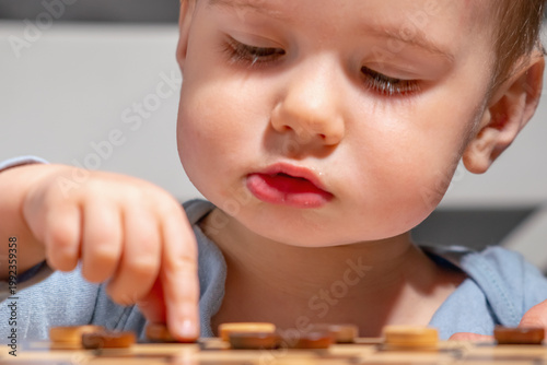 Child reaching for a game piece, moment of decision and curiosity.