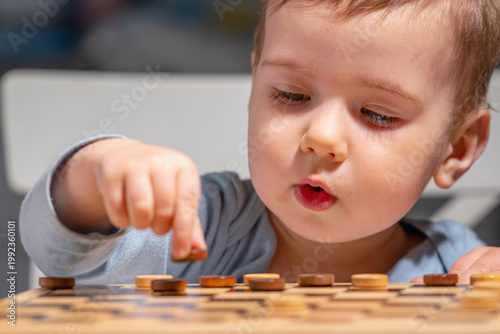 Toddler focused on board game, developing brain and concentration.