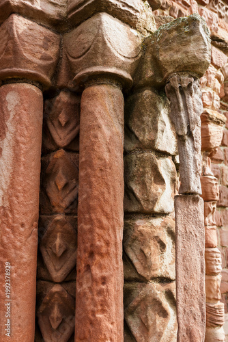 Close-up of heavily eroded sandstone pillars at the entrance of Lindisfarne Priory, Holy Island, Northumberland, England, UK