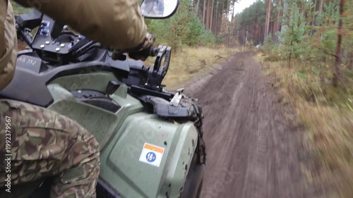 Six-wheeled ATV navigating a muddy forest trail with a rider in camouflage gear, showcasing dynamic movement and rugged terrain