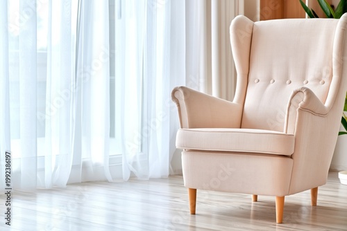 Cozy Chair Sitting by Large Windows in a Bright Room With White Curtains