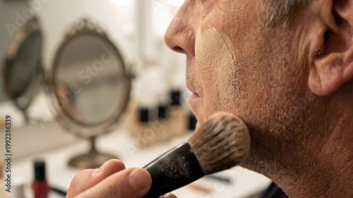 Elderly man applying makeup in a vanity setting with mirror  