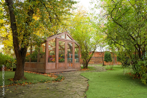 Foto Garden with a greenhouse surrounded by trees and pathways during autumn season i