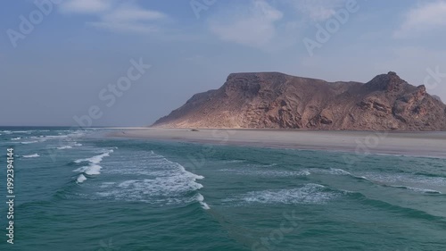 Aerial view of a remote sandy beach with turquoise ocean waves, socotra island