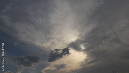 Dark and gloomy overcast sky dominated by heavy grey storm clouds with a faint light breaking through before a heavy rainfall

