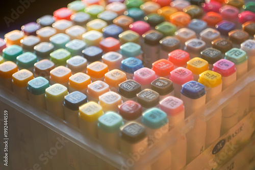 Fotografija High-angle shot of a vibrant set of professional multi-colored markers arranged on a white workspace, symbolizing creativity, artistic hobby, and design inspiration
