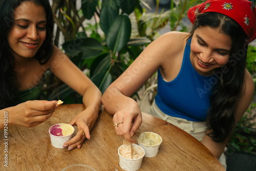 Two Friends Enjoying Ice Cream at a Cafe in the Afternoon Sun