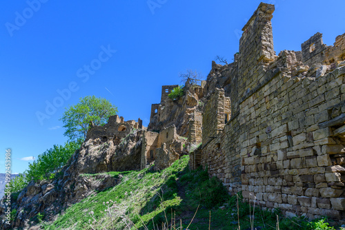 Ancient Fortress Ruins on a Cliffside Under a Blue Sky