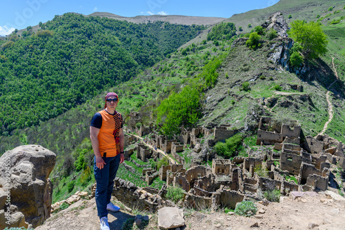 Abandoned village ruins nestled in a mountain landscape with a person