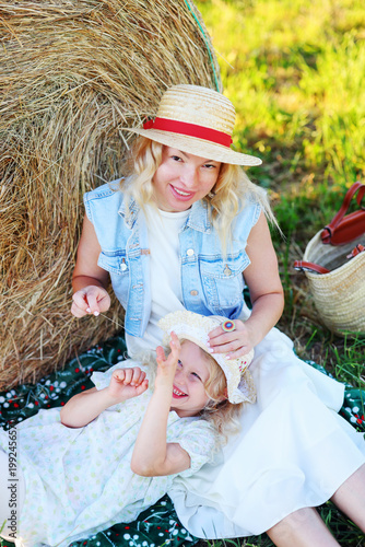 Happy family moment outdoors, mom and child enjoying countryside picnic.