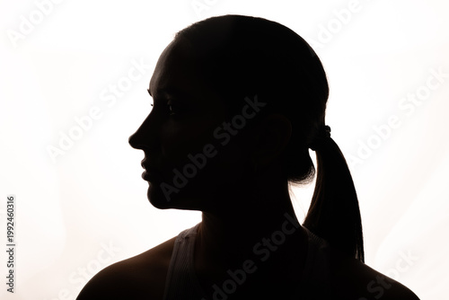 Foto Backlit silhouette of woman standing in front of softbox in dark studio