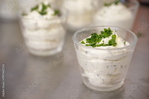 Herb butter garnished with parsley, filled into several small glasses, to serve this flavorful condiment at restaurant tables, copy space, selected focus