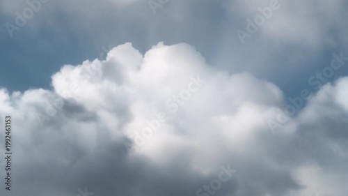 Sunlight breaks through dark clouds, creating a dramatic, ethereal scene against a blue sky