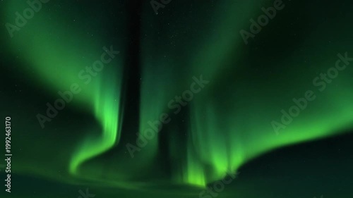 A vibrant display of the aurora borealis, with bright green bands across the night sky