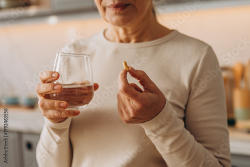 Old woman holds medical supplements for health care at home