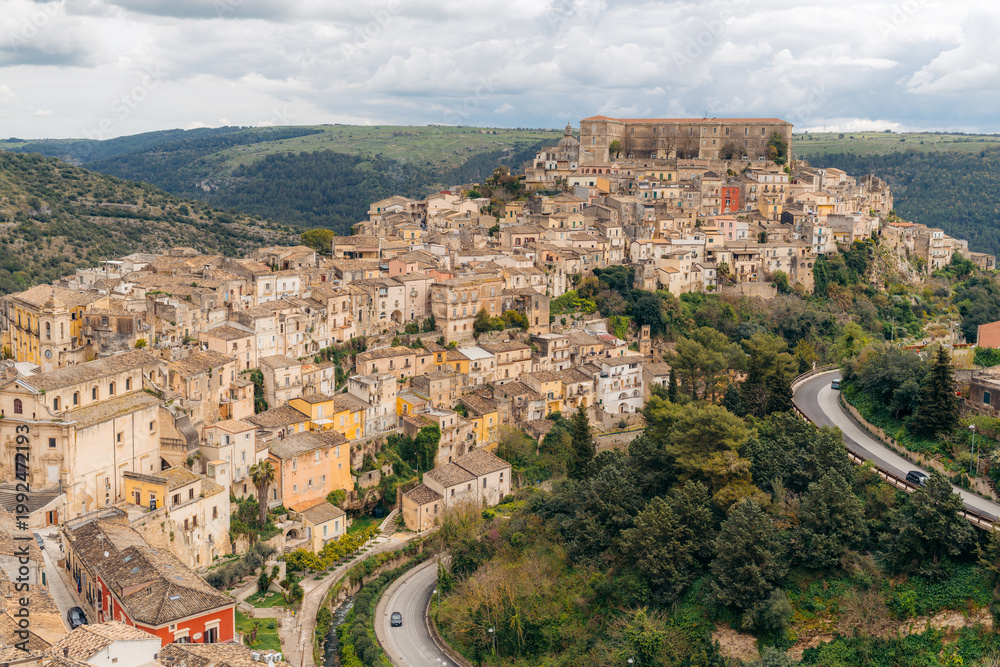 Naklejka premium Ragusa, Sicily: A view of the historic town and its architecture under a cloudy sky