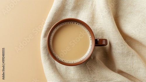 close cup coffee beige fabric background cup brown color has handle right side coffee light brown color appears freshly brewed fabric soft beige color draped over cup creating subtle texture