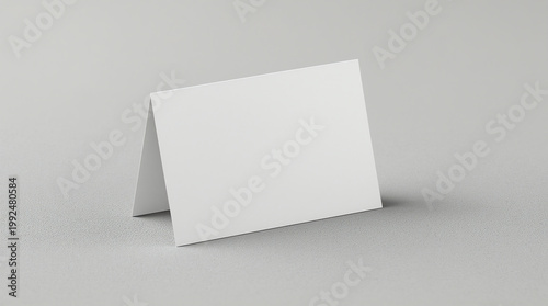 Single folded table tent card standing on a neutral surface, angled slightly to the side 