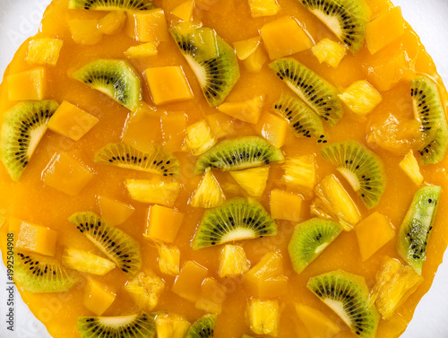 Delicious cheesecake with with pineapple, kiwi and mango top view