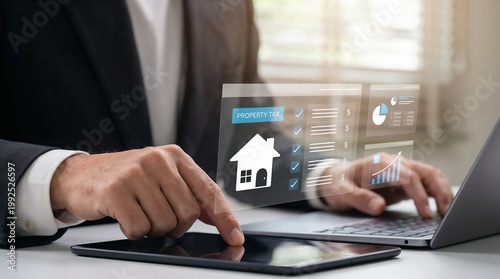  merchant using a tablet and laptop. A holographic house icon with a (Property Tax) label, a digital checklist, and floating financial charts in the air, real estate management, smart housing data.