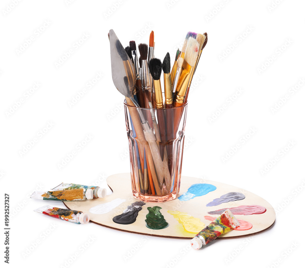 Fototapeta premium Paintbrushes with knife in glass, paints and palette isolated on white