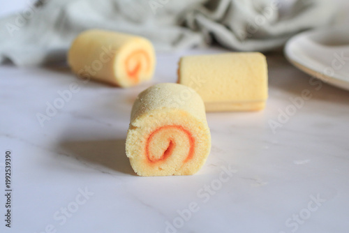 Homemade orange yam rolls on marble table. Soft cake texture. Dessert and bakery.