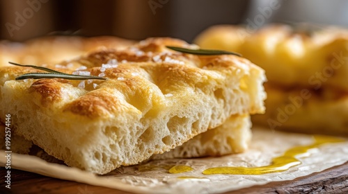 Golden brown focaccia bread sliced with fresh rosemary and coarse salt, a delicious Italian baked good.