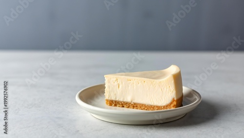 A slice of creamy cheesecake with a crumbly base on a simple plate