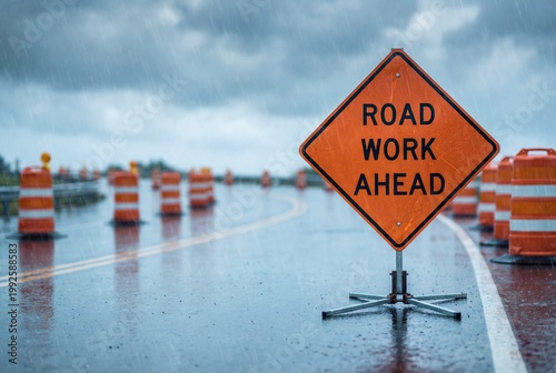 Road Work Ahead sign on wet highway during rain