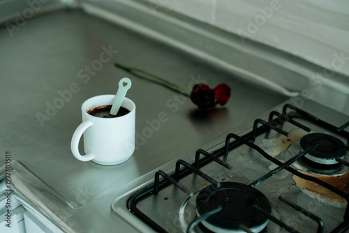 Fotografija Minimal kitchen scene with coffee cup on stove, simple lifestyle, calm morning routine and home environment
