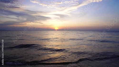 Dramatic Purple and Blue Sunset Sky Over Open Ocean with Golden Sun Reflection on Sea Surface
