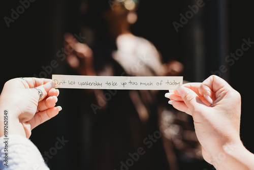 Foto Hands holding a slip of paper witha quotw that says Don't let yesterday take up