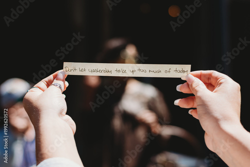 Foto Hands holding a slip of paper witha quotw that says Don't let yesterday take up