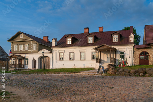 Historical merchant buildings of estates on the main street of Izborsk Pechorskaya Street on a summer sunny day, Izborsk, Pskov region, Russia