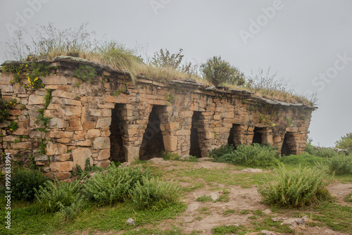 Ancient Stone Burial Chambers in Misty Mountain Landscape