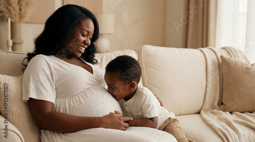 Mother's Day expectant mother with toddler son on couch showing sibling bond affection anticipation for lifestyle magazine editorial content photography