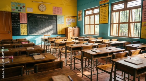 An empty Indian primary school classroom featuring colorful walls and student desks.