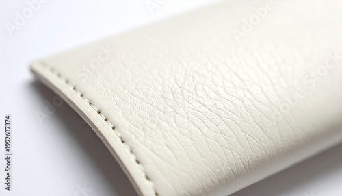 Close up of textured off white leather pouch with stitched seam detail